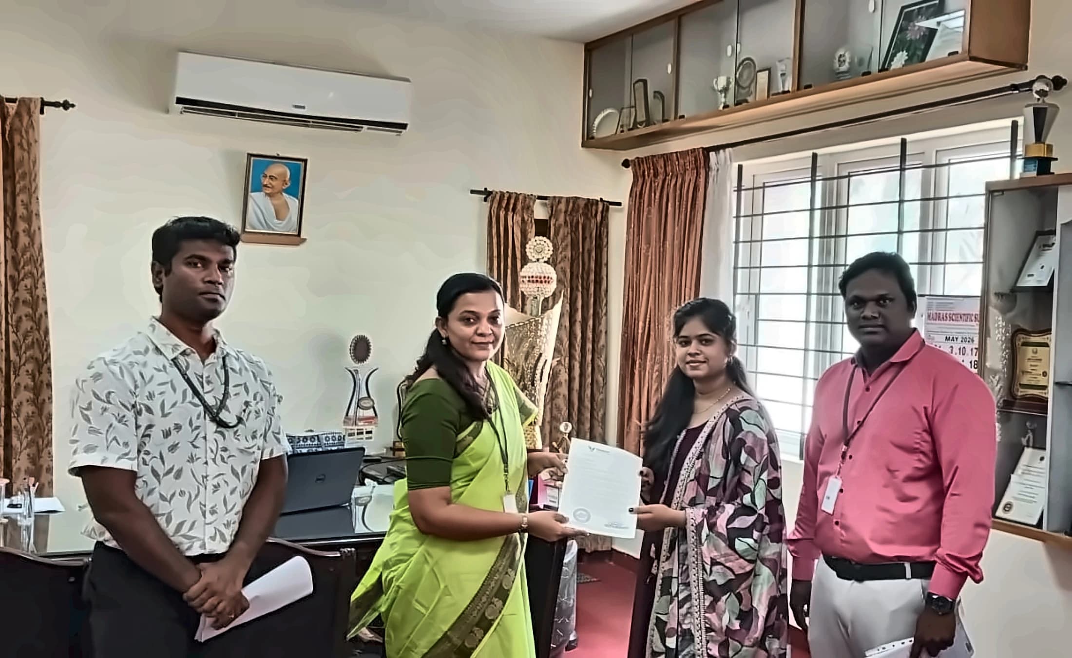 S.N.Rathnadevi presenting an SNR AUTOMATIONS document to a college principal
